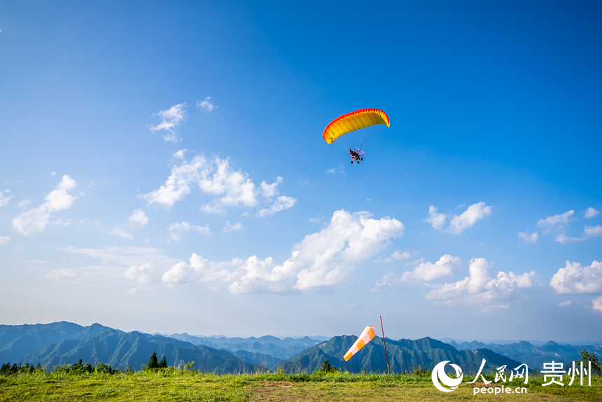 游客在野玉海飛行營(yíng)地乘動(dòng)力滑翔傘體驗(yàn)云端觀景。人民網(wǎng)記者 涂敏攝