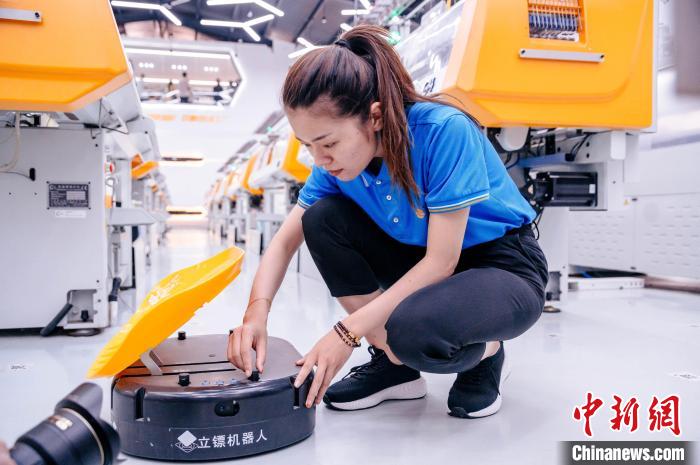 圖為員工在調(diào)試AGV搬運機器人?！±钅宪?攝